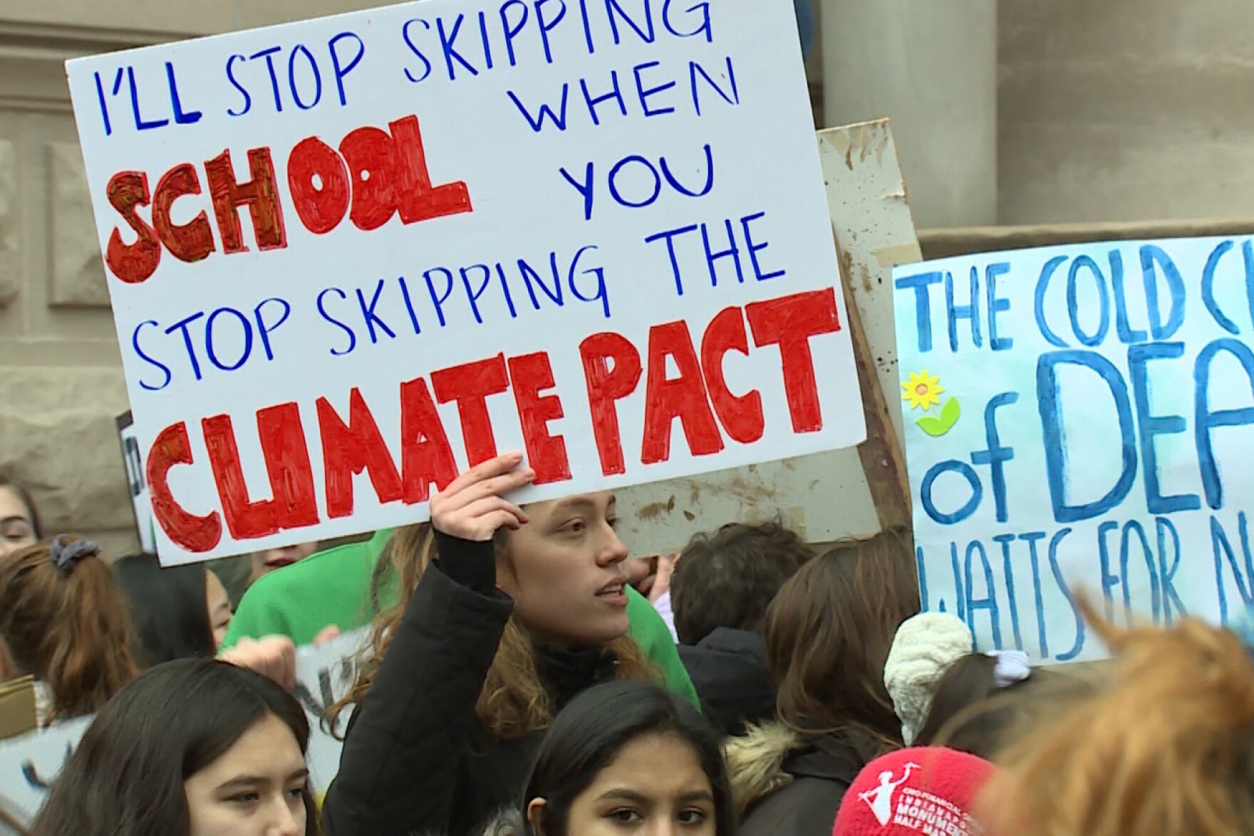 Students gather with signs on the steps outside of the Indiana Statehouse. The only poster not cut off by the crop says, I'll stop skipping school when you stop skipping the Climate Pact.